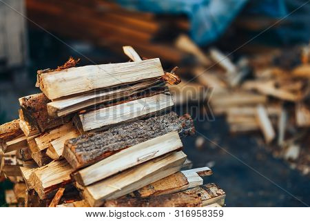 A Pile Of Stacked Firewood, Prepared For Heating The House. Gathering Fire Wood For Winter Or Bonfir