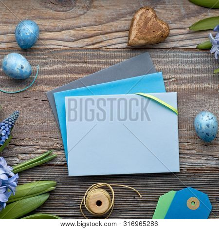 Top View Of Paper Cards With Copy-space, Blue Hyacinth Flowers And Easter Eggs On Rustic Wooden Back