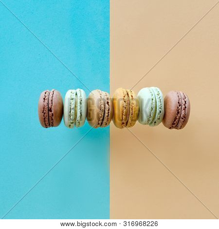 Row Of Weet And Tasty Macarons, Flat Lay On Split Paper Background, Square Composition