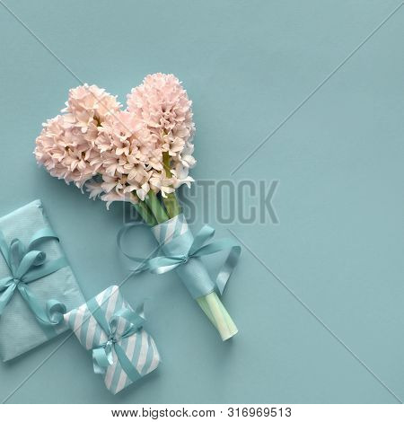 Springtime Turquoise Background With Hyacinth And Gift Boxes Wrapped In Stripy Paper. Flat Lay On Pa