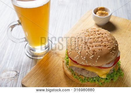 Burger With Beef Patty, Salad, A Slice Of Tomato And Cheese, Onions And Sauce With Paprika In A Gril