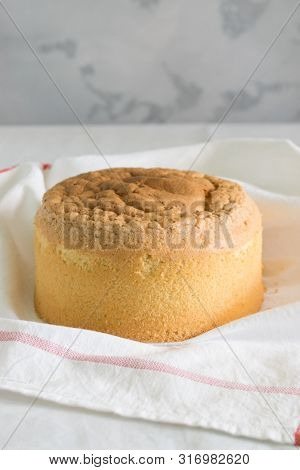 Tall, Ruddy Sponge Cake On A White Towel With A Red Stripe