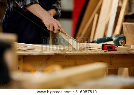 Closeup Of Unrecognizable Carpenter Carving Wood While Working In Joinery Lit By Sunlight, Copy Spac