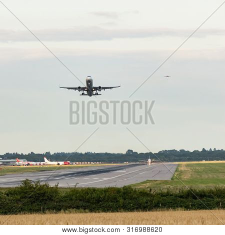 London Gatwick Airport, Uk- August 07 2019: An Airplane Takes Off As Others Come Into Land In An Air
