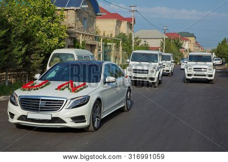 Wedding Cortege In The Baku City Centre. Wedding Cortege At The Head Of The Car. Red And White Flowe