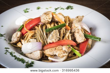 Tallarin Saltado Traditional Peruvian Meal. Peru. On A White Plate