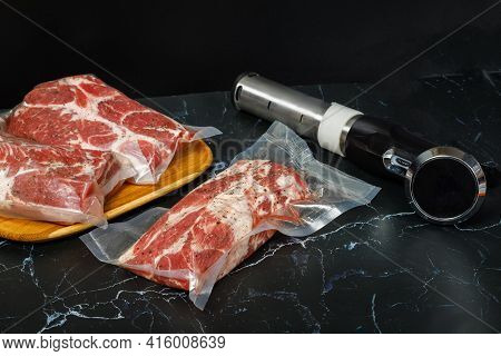 Meat In Bags And Sous Vide Devices On A Black Background.