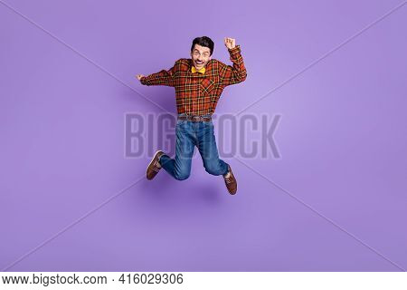 Photo Of Funny Excited Guy Jump Open Mouth Wear Spectacles Bow Tie Plaid Shirt Jeans Footwear Isolat