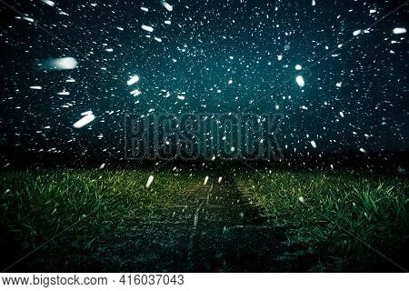 An Unusual Sight Of A Snow Storm On The Green Field In Spring During The Sunset. Dramatic Springtime