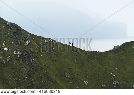 Kalsoy Island With Kallur Lighthouse On On Faroe Islands, Denmark, Europe. Clouds Over High Cliffs, 