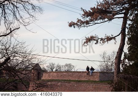 Belgrade, Serbia - January 1, 2021: Selective Blur On A Young Couple, Lovers, Tourists, Sitting Toge