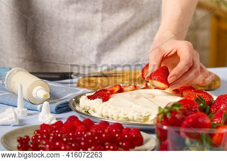 Woman Baker Stacks Strawberries On Meringue Strawberry Cake Base. Homemade Strawberries Cake Made Fr