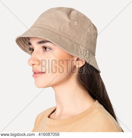 Beautiful woman in beige bucket hat fashion studio shoot