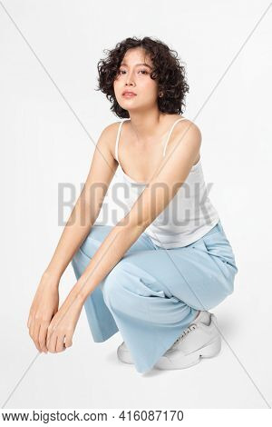 Woman sitting and posing in simple outfit full body