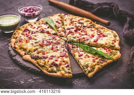 Tart flambee (Flammkuchen) with ramson sour cream (bear leek), onion and bacon