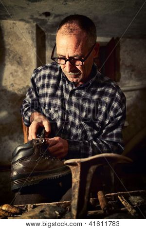 Schuster bei der Arbeit mit alten Werkzeugen