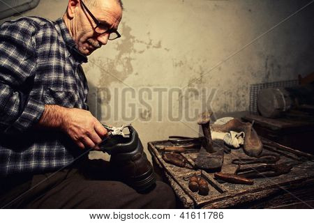 Schuster bei der Arbeit mit alten Werkzeugen