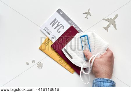 New Normal Travel During Covid-19 Restrictions, Flat Lay On White Background. Hand Hold German Passp