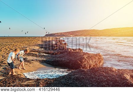 Young Barefoot Boys Playing With Sea Waves With Foam On Sand Prasonisi Beach At Sunset On Clear Hori