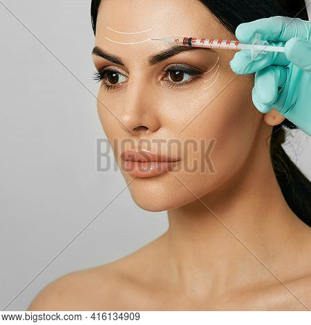 Botulinum Toxin Injections In A Womans Forehead For Blocking Mimic Wrinkles. Beautiful Face With Arr