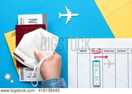 New Normal Travel During Covid-19 Restrictions, Flat Lay On Blue Yellow Paper. Hand Hold German Pass