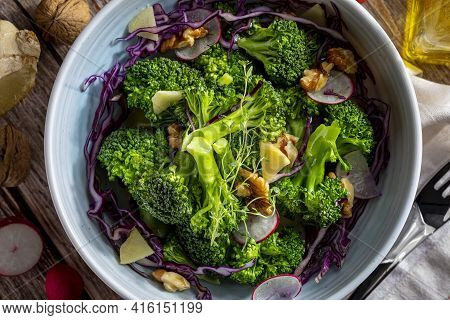 Close-up Of Plate With A Healthy Vegetarian Salad Of Steamed Broccoli, Fresh Radishes, Walnuts, Red 