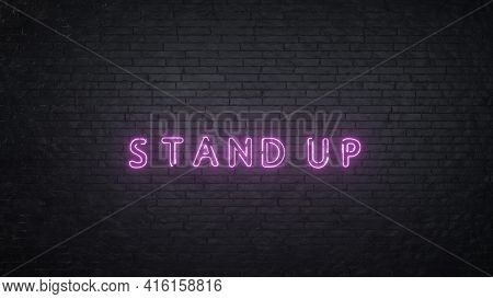 Stand Up Neon Sign On Black Brick Wall Background. 3d Rendering.