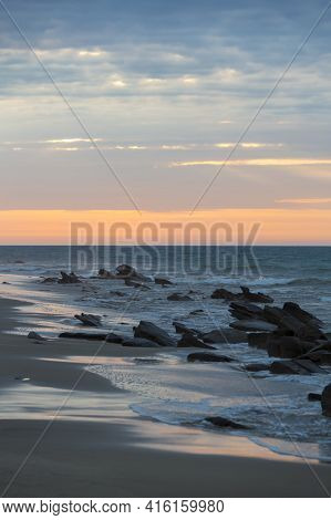 Sunset On The Beach Of Punta Sal With Rocks Standing In The Water, Near Mancora, Peru.