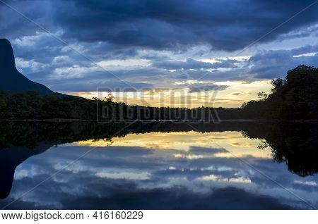 Sunset On The Auyantepui Mountain In The Canaima National Park And Its Reflection In The Water Of Th