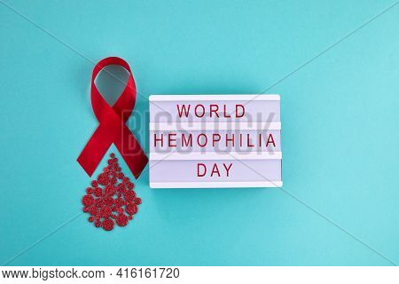 Awareness Oncept With Blood Drop And Red Ribbon. World Hamophilia Day Or Blood Donor Day.