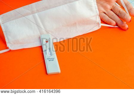 Test For Coronavirus On An Orange Background. On A Matte Background A Sensitive Strip For Coronaviru