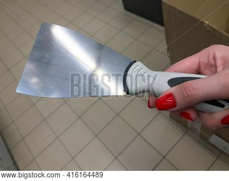 Scraper For Applying Mastic, Plaster. Painting Works. Diy Home Repair. A Scraper In The Hands Of A W