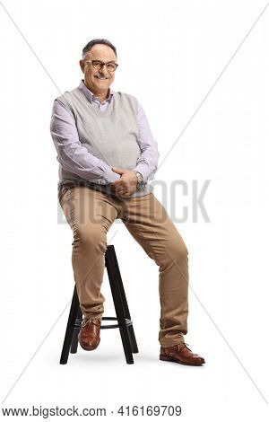 Corpulent mature man sitting on a high chair isolated on white background