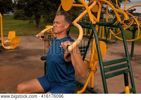 Senior Man Working Out At An Outdoor Fitness Park In Parque Das Garças, Brasilia
