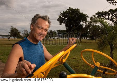 Senior Man Working Out At An Outdoor Fitness Park In Parque Das Garças, Brasilia