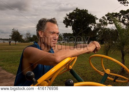 Senior Man Working Out At An Outdoor Fitness Park In Parque Das Garças, Brasilia