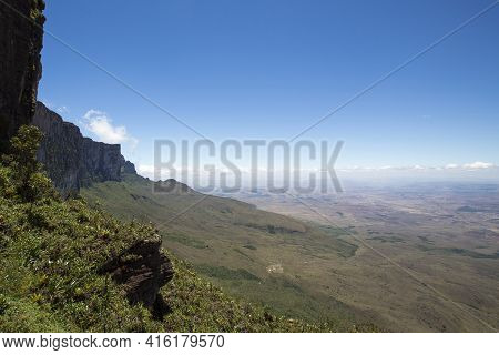 Sheer Cliffs Of Mount Roraima - Landscape With Blue Sky And Clouds Background. View On The Gran Saba