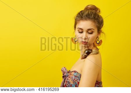 Beautiful Young Woman With A Snail On Her Body On A Yellow Background, Cosmetology Procedure