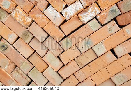 Close Up Texture Of Piled Bricks. Background From Red Bricks Stacked On Top Of Each Other. Construct