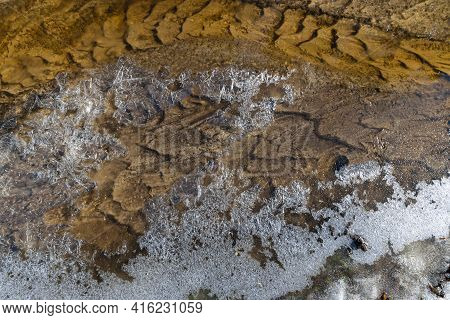 Curve Of The Patterned Streambed And The Ice Crust At The Edge Of The Current On A Spring Morning