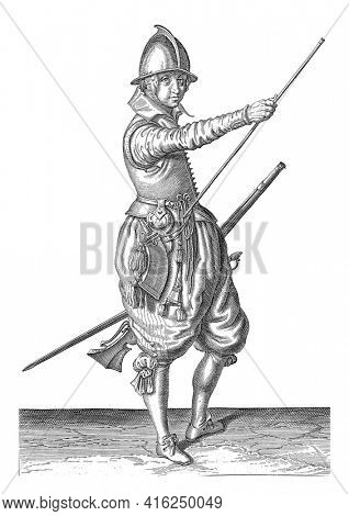 A soldier, to the right, holding a rudder with his left thigh and bringing his right hand to the end of his ramrod, which he leans against his right side , vintage engraving.