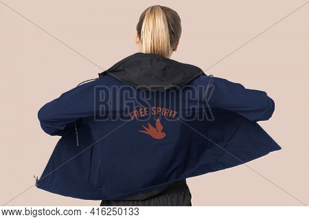 Blonde woman in windbreaker jacket for sportswear fashion photoshoot rear view