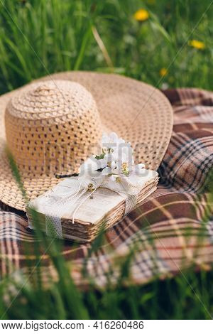 Hat And A Book Lie On A Blanket During A Picnic