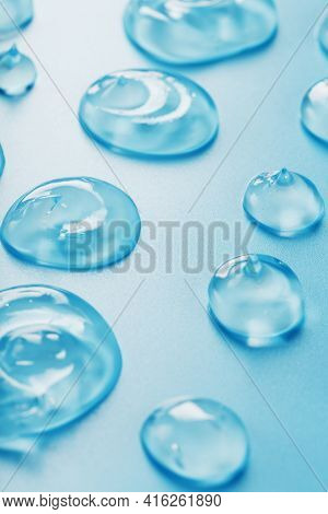 Drops Of Gel With Hyaluronic Acid In The Form Of A Smear Of Glossy Texture On A Blue Background.