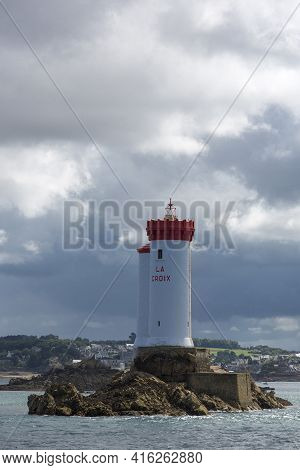 Cloudy Sky And The Lighthouse Of La Croix, A Monument In The Commune Of Ploubaslanec In The Cotes D'