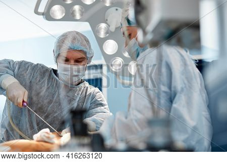 Cosmetic Liposuction Surgery In Actual Operating Room Setting Showing Surgeon Hands And Cannula.