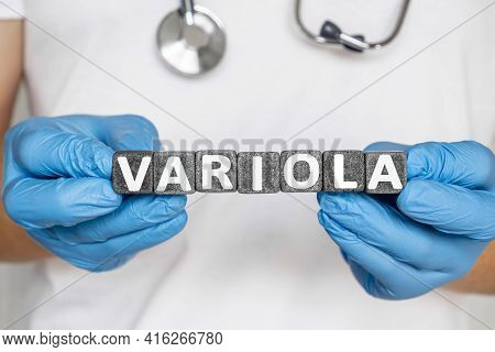 Variola - Word From Stone Blocks With Letters Holding By A Doctor's Hands In Medical Protective Glov