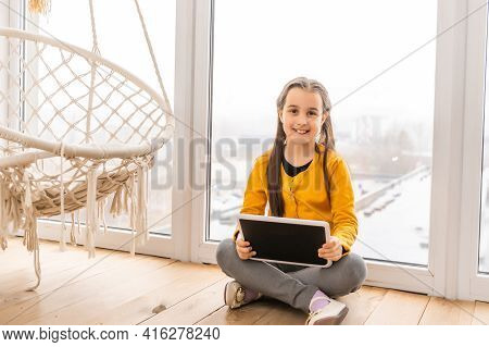 Shot Of Little Girl Using A Domotic System With Her Digital Tablet While At Home.