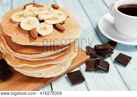 Homemade Pancakes With Banana And Chocolate On A Light Blue Wooden Background With A Cup Of Coffee I