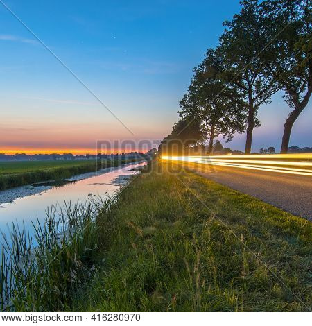Netherlands Open Polder Landscape With Canal And Traffic Lights On Road In Open Grassland Countrysid